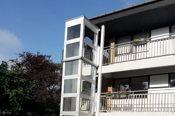 Udendørs elevatorlift i egen hvid og glas elevatorskakt fra HYDRO-CON Udendørs elevatorlift | HYDRO-CON
